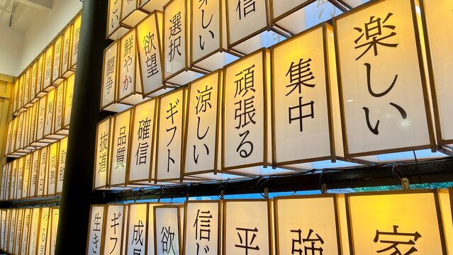 Close-up of Japanese lanterns with kanji characters, warm lighting, traditional Asian decor, cultural festival ambiance, Japan street market theme signs background.