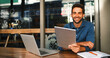 © peopleimages.com - Portrait, smile and tablet with man in coffee shop to research for small business startup. Laptop, schedule and website with happy freelance employee person of cafe or restaurant as customer