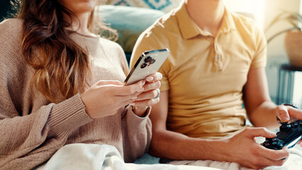 Poster - Phone, controller and hands of couple in home for entertainment, gaming or social networking. Cellphone, gamer and man with woman for relaxing with mobile app or esports in living room at house.