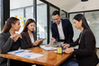 © SOMKID - Group of business people working together with dashboard analysis and data management a meeting table in office.