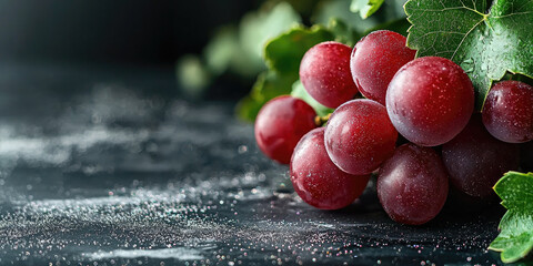 Poster - Red table grapes with green leaves on dark background, fresh juicy fruit, healthy snack, natural vibrant mood