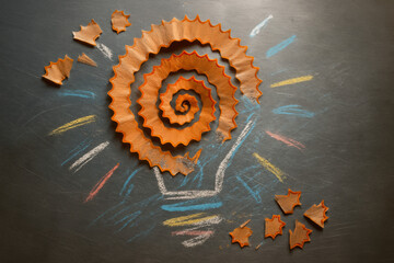 Poster - The illustrates innovation and creativity through a spiral pencil shavings on a reflective surface suggesting ideas transforming into actionable concepts