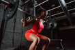 © oneinchpunch - Fit young woman in red sport outfit making workout in the gym