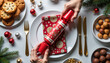 © Evialina - Pulling Christmas cracker at holiday table with treats