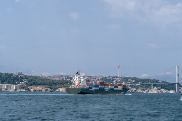 Poster - Bosphorus Strait showcases a cargo ship navigating between the European and Asian shores on a clear day