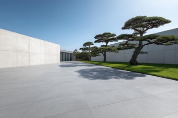 Aufkleber - Large outdoor paved area with pine trees, grass, and a modern concrete building, creating a peaceful and contemporary architectural scene