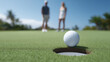 © emzee - Couple Golfing On Sunny Golf Course With Ball At Hole