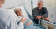 © peopleimages.com - Healthcare, doctor and old couple in hospital, conversation and advice for cancer treatment. Diagnosis, medical emergency and senior woman with elderly man, recovery and consultation with illness