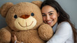 © 288 Studio - Young woman happily hugging huge bear soft toy. Concept of kidult industry, emotional care, stress relief