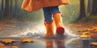 © anetlanda - Child wearing rain boots jumping into puddle.