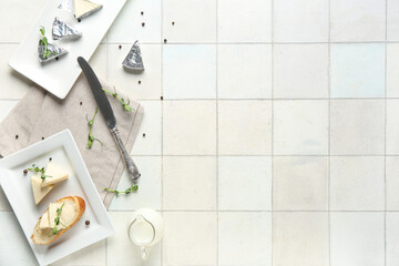 Wall Mural - Plate with fresh bread, triangles of tasty processed cheese and micro green on light tile table