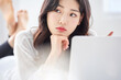 © Dialogue Frame - Thoughtful Young Asian Woman Working Remotely on Laptop in Bright Minimalist Home Office