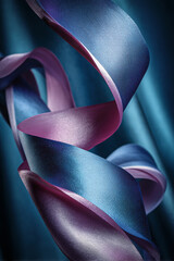 Poster - A close up shot of swirling ribbons in shades of blue and pink against a dark teal background
