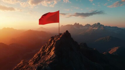 Wall Mural - Red flag on a rocky mountain peak during a stunning sunset, symbol of achievement