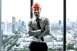 © Jack Tamrong - Handsome Caucasian male architect with safety helmet standing arms crossed in high rise office with skyscraper downtown view background