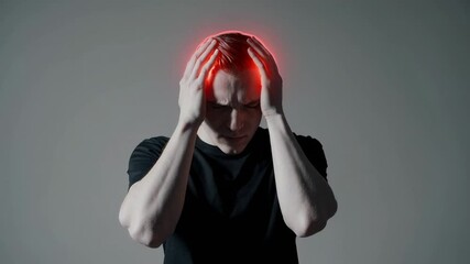 Fototapete - Young man experiencing severe migraine, gripping head with hands, red glow symbolizing intense pain and mental health struggle on neutral background