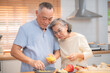 © Hip.hub - Elderly couple cooking together in a modern kitchen with natural light and warm atmosphere