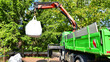 © Grand Warszawski - Crane with a big bag of stones. It is a white big bag with decorative stones for the property.