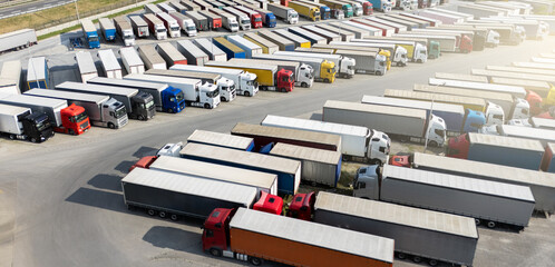 Poster - Aerial view of a large truck parking lot at a logistics hub, with multiple commercial semi trucks parked in organized rows