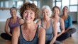 © Pinklife - A group of confident women smile brightly while seated in a yoga pose, showcasing their unity and joy in a shared fitness journey, embodying health and well-being.
