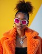 © Pete - Stylish young woman in sunglasses and orange fur coat against a bright yellow background. Modern fashion, diverse youth culture, individual expression. Portrait, bold colors, accessories, lifestyle.