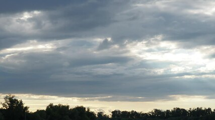Poster - Witness the captivating journey of light slicing through layered clouds during twilight, showcasing natures artistry in a serene landscape. A transformative display unfolds overhead. Quick time lapse