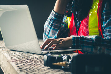engineer carefully inspecting construction plan data using a laptop computer on the job site.
