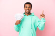 © luismolinero - Young man taking a lot of money over isolated pink background pointing up a great idea