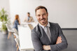 © Dusan Petkovic - Portrait of professional businessman standing at corporate office with arms crossed during the meeting and smiling at camera.