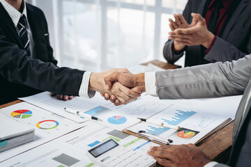 Poster - A man shakes hands with another man in a business setting