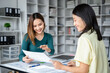 © Freedomz - Two women are sitting at a desk with papers in front of them