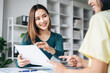 © Freedomz - Two women are sitting at a desk with a white piece of paper in front of them