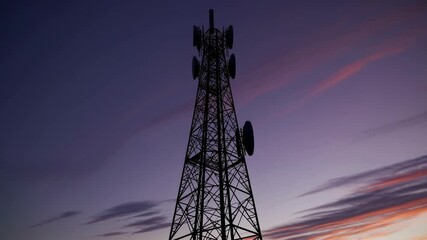 Aufkleber - Giant communication tower stands against vibrant sunset sky in urban area