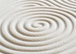 © Noppakun - Concentric spiral patterns drawn in fine white sand, evoking calm and tranquility, often seen in Zen gardens.