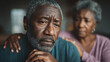 © Inspire Shots Hub - Close-up of a senior African American man, pensive expression, comforted by a woman's hand on his shoulder, conveying empathy and support, depicting themes of aging and companionship
