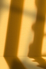 Poster - Light and shadow on orange background.Studio background with window light on yellow podium with natural abstract sunbeams for Autumn banner,Blank interior yellow wall and floor Fall product display