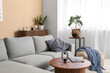© Pixel-Shot - Comfortable sofa, pouf and table in interior of light living room, closeup