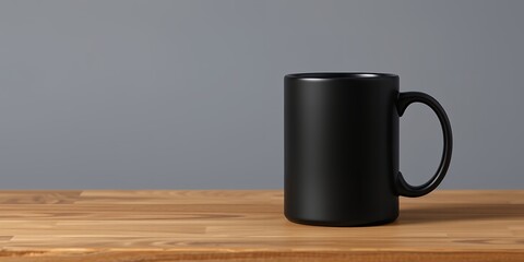 Poster - A black mug is placed on a wooden table with a gray background in a minimalist composition style