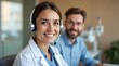 © Orislava - Smiling Caucasian female healthcare worker with headset, accompanied by a male colleague, exuding professionalism and warmth.