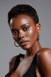 © Jaroon - Striking beauty of African descent exudes confidence in a portrait with slicked-back hair, her flawless skin illuminated in soft studio lighting.