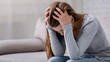 © Prostock-studio - Unhappy young woman with head in her hands sitting on couch, crying and feeling depressed. Desperate millennial lady suffering from mental problems, broken heart or mood disorder