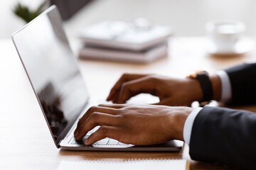 Aufkleber - Side view of unrecognizable black manager typing on modern laptop, sending emails or working on business project, office interior, cropped. African american businessman hands on keyboard, closeup