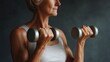© Elena - Older lady exercising with dumbbells