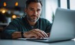 © moon - Focused middle-aged man with beard working on laptop in modern indoor setting during daytime