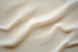 © k - Close-up view of soft beige fabric with gentle folds and a smooth texture creating subtle shadows