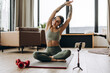 © Maria Vitkovska - Fitness influencer recording online yoga class at home