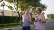 © ChayTee - Young adult child workout outdoor public park run walk hold water bottle with mature middle age old mum. Love health care older mom asia elder people happy family protect aging fun joy city life sport