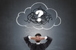 © Who is Danny - Businessman thinking with hands behind head facing chalk-drawn cloud and question mark symbolizing confusion and curiosity on dark background.