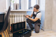 © anatoliycherkas - Professional plumber repairing heating system in modern apartment
