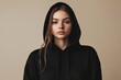 © Pavel - Woman in a black hoodie poses against a neutral background, highlighting a casual and comfortable style suitable for various occasions and fashion choices
